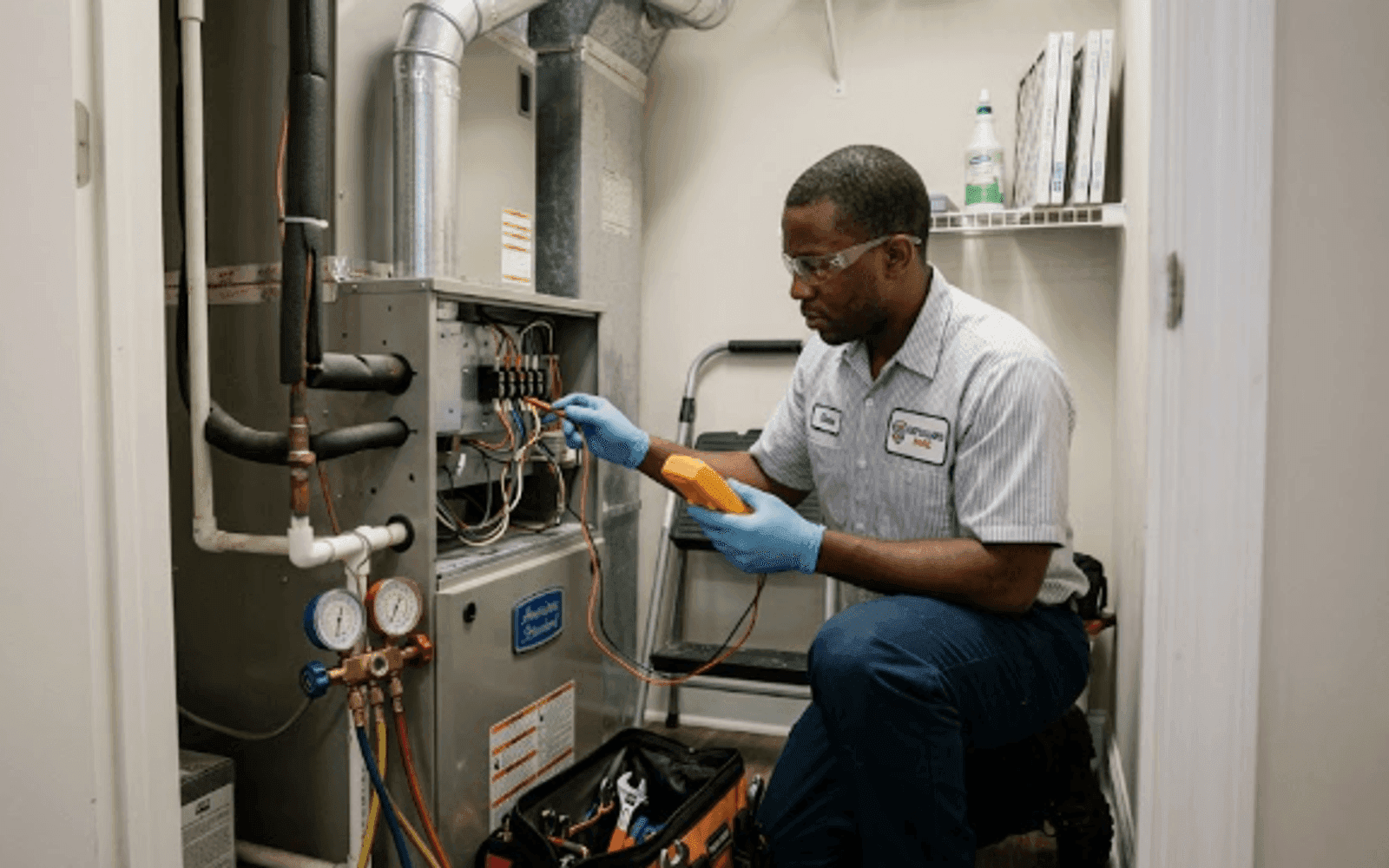 HVAC technician servicing an indoor air handler in a US home
