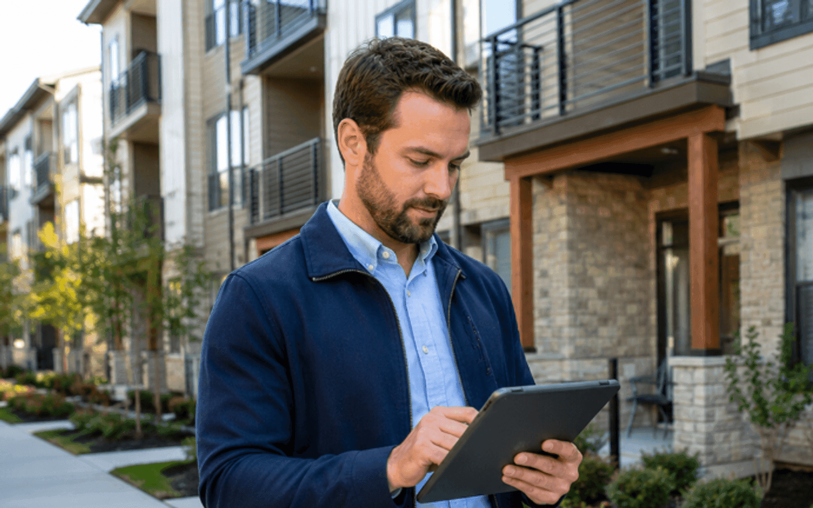 Property manager inspecting a well-maintained US apartment building exterior
